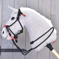 A gray plush hobby horse head with a black bridle, red accents, and the Hobby Horse LarDen Rope set Spark is attached to a wooden stick, shown against a light wooden panel background.