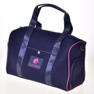 The Hobby Horse LarDen Sports Bag Pink features navy blue fabric with pink trim, dark handles, an adjustable strap, a front snap pocket, and a front “LarDen” horse head logo.