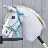 The Hobby Horse LarDen Rope halter Turquoise is shown on a plush hobby horse with a light gray head, white mane, and blue bridle, mounted on a wooden stick before a gray wooden wall.