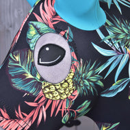 Close-up of the Hobby Horse LarDen Protective Suit Pineapple (Lycra), featuring a colorful tropical pattern with leaves, yellow pineapples, and a large cartoonish gray eye—perfect for trendy hobby horse enthusiasts.