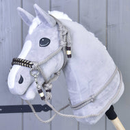The Rope set Splendid by Hobby Horse LarDen features a gray plush hobby horse with a white mane, black eyes, and rope bridle and reins, shown against a gray wooden wall.