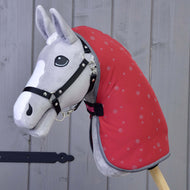 The Hobby Horse LarDen plush hobby horse features a black bridle and a Stable Blanket Raspberry, mounted on a wooden stick—ideal for imaginative play and horse training in front of any backdrop.