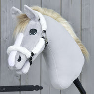 The Hobby Horse LarDen Fur Halter Teddy Classic is a plush hobby horse with light gray fur, a white mane, white facial markings, and a white halter, shown mounted on a stick against a wooden background.