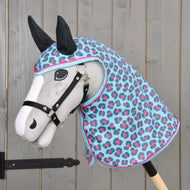 The Hobby Horse LarDen Raincoat Blue Leopard features a plush hobby horse with a white face, black bridle and ears, and a blue, pink, and gray spotted raincoat hood—all set against a gray wooden background.