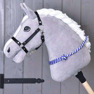 The Hobby Horse LarDen "Cordeo blue stripe" is a plush gray hobby horse with a white mane, black halter, and blue-striped cordeo, mounted on a wooden stick and shown against a gray wooden wall.
