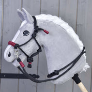 The Rope set Maroon by Hobby Horse LarDen is shown in front of a gray wooden wall, featuring maroon-colored ropes designed for hobby horses.