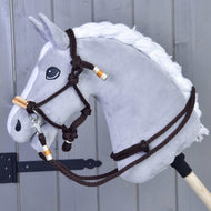 The Hobby Horse LarDen Rope set Orange is displayed against a wooden fence background, featuring an orange rope set securely attached to a sturdy wooden stick.