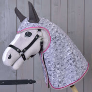 The Hobby Horse LarDen Raincoat Valentine is a plush hobby horse with a black bridle and quilted light purple hood with geometric pattern and pink trim, shown against a wooden panel background.