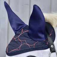 Close-up of a horse wearing the Hobby Horse LarDen Ear Bonnet Pink Heart for stylish fly protection, featuring pink heart designs and black strap, set against a light wooden background.