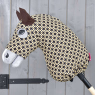 The Hobby Horse LarDen "Hobby Horse Protective suit Luxus Design" features a black and beige patterned head, felt ears, sewn-on eye, white snout, and washable materials, all mounted on a wooden stick against a gray wall.