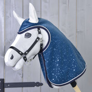 The Hobby Horse LarDen "Raincoat Derby" is a white plush hobby horse with a black halter and shiny blue raincoat decorated with water droplets, displayed on a light wooden plank background.