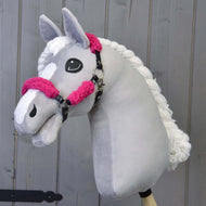 The Hobby Horse LarDen features a handmade grey hobby horse with a white mane and face patch, wearing the Black halter with complete pink fur - leatherette, shown against a wooden background.