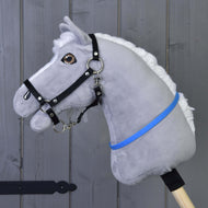 A grey plush Hobby Horse with a white mane and black halter wears the bright blue cordeo around its neck