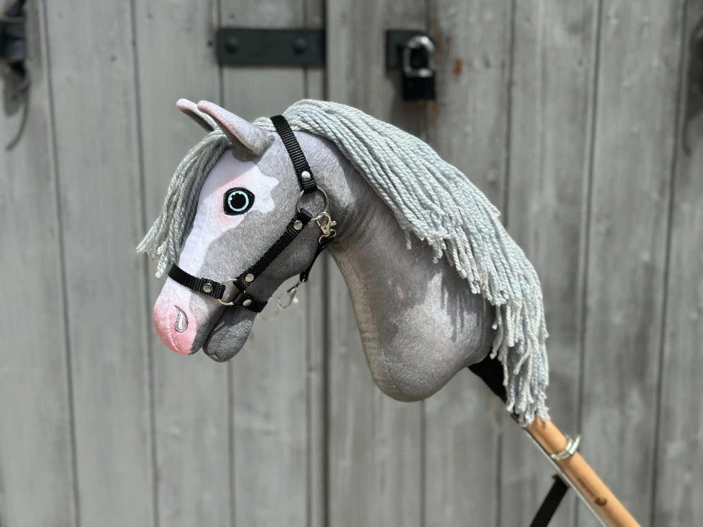 The Hobby Horse Midnight Blue with Black Halter by Hobby Horse LarDen (size S) features a handmade design, a blue fabric head, black halter, and is mounted on a wooden stick.