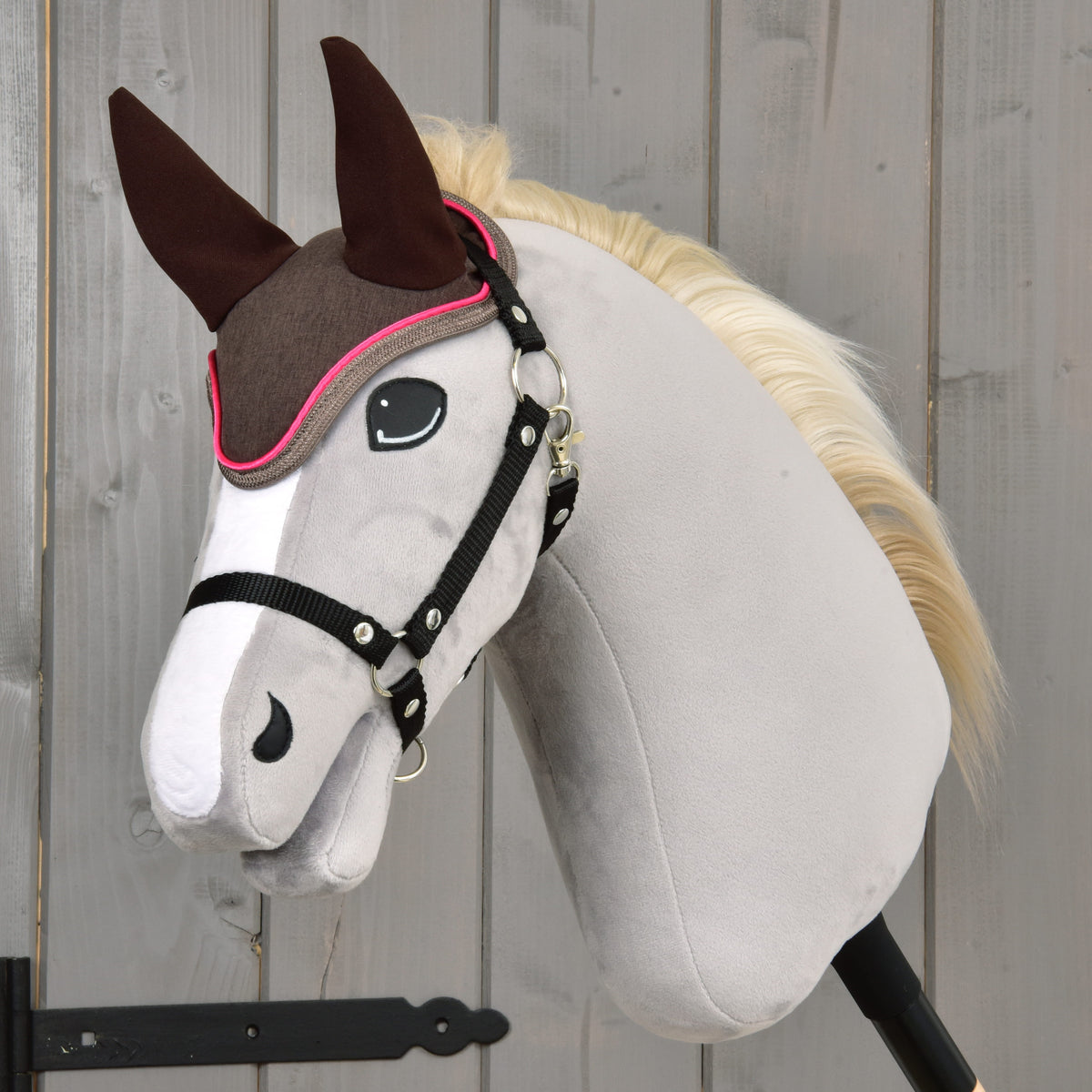 Brown ear bonnet with bright pink edging worn on a grey Hobby Horse with blonde mane