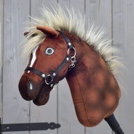 A close-up of the Hobby Horse LarDen “Hobby Horse Cinnamon with Black Halter” (size S), featuring a plush brown body, a fluffy mane, and black halter, reminiscent of a proud stallion, set against a wooden background.