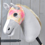 Pink and orange Hobby Horse mask without ears Mirage worn on a grey Hobby Horse