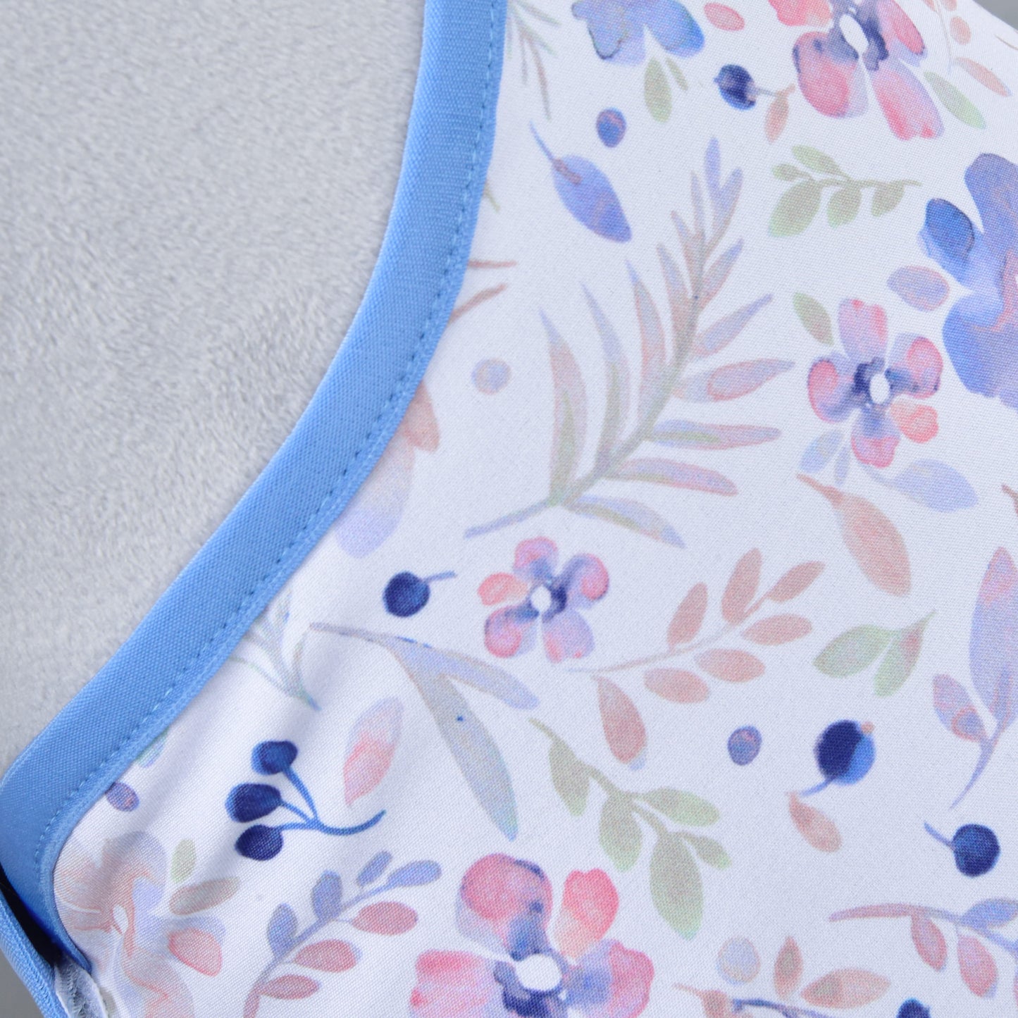 Close-up of the Hobby Horse LarDen Set Vanessa NEW, featuring Winter Softshell fabric with blue trim and a pastel floral pattern—pink, purple, and blue flowers with green leaves—ideal for a cozy Hobby Horse blanket and ear bonnet set.