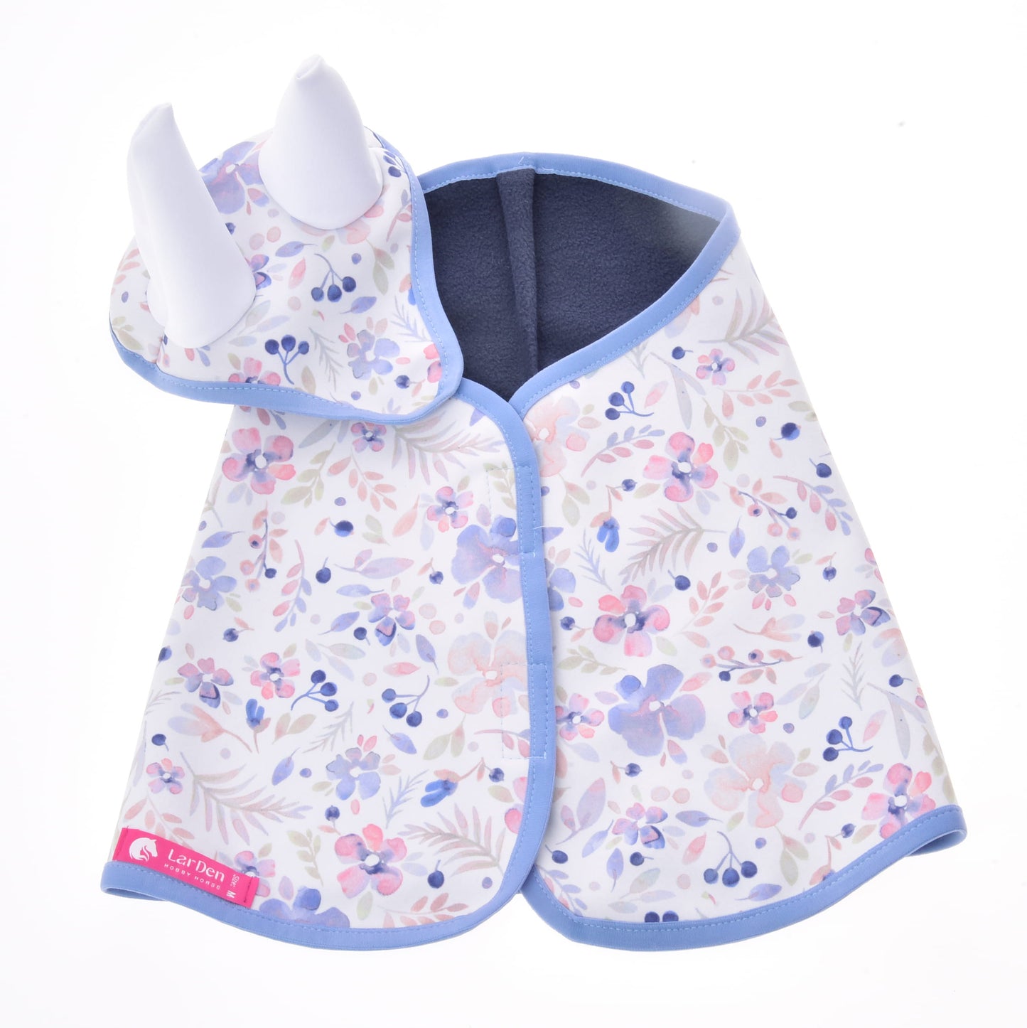 The Set Vanessa NEW by Hobby Horse LarDen features a baby cape and matching hat with white horn-like details and a pastel floral pattern with blue trim—ideal as a whimsical blanket set or playful ear bonnet for little ones.
