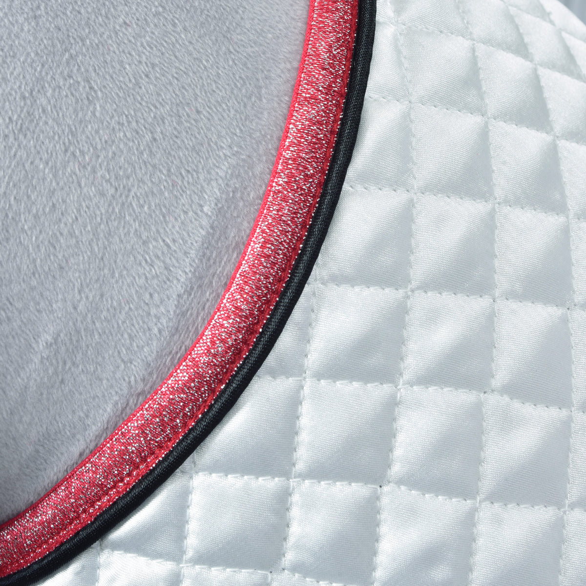 Detail of glittery pink and black piping along the quilted white satin blanket edge on a grey Hobby Horse