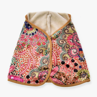 The Blanket Jungle by Hobby Horse LarDen is a vibrant patterned cape with a soft cream lining, tan trim, and pink, green, blue, and orange floral and dot designs. A pink LarDen label appears on the lower left corner.