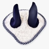 A close-up of the Hobby Horse LarDen Ear Bonnet Cube Blue, featuring soft navy ear-like protrusions on a white fuzzy base with black and white checkered trim for stylish horse insect protection.