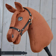 A “Build your horse” hobby horse by related_to_12441055625556, featuring a dark chestnut design with a black bridle and striking blue eyes, is displayed in front of a gray wooden background.