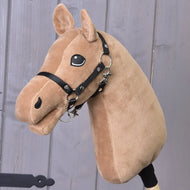 A caramel hobby horse with a black harness stands before a wooden wall, showcasing the “Build your horse” by related_to_12441055625556—an invitation to personalize your own unique and playful hobby horse.